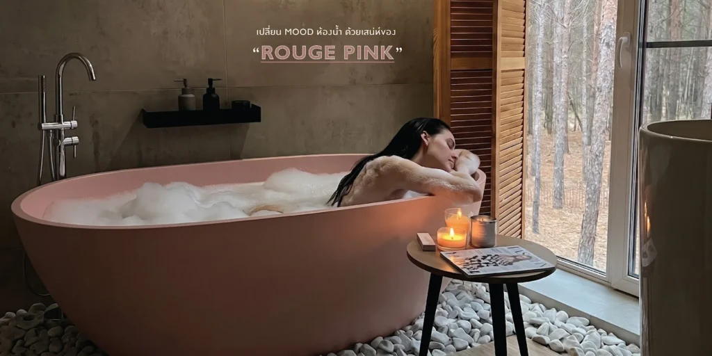 ผู้หญิงแช่ตัวในอ่างอาบน้ำลอยตัวสี Rouge Pink ที่มีฟองสบู่ ข้างหน้าต่างวิวป่าสน พร้อมเทียน โต๊ะข้าง และข้อความ ROUGE PINK